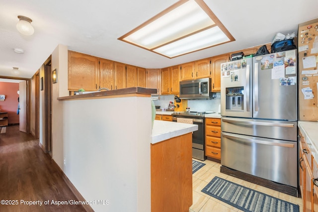 565 Sandrock Dr, Craig, CO 81625 - kitchen featuring appliances with stainless steel finishes, light countertops, and brown cabinets