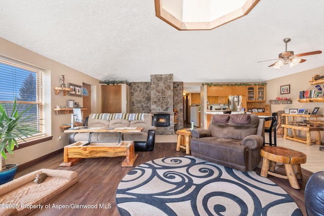 565 Sandrock Dr, Craig, CO 81625 - living area with wood finished floors, ceiling fan, a fireplace, baseboards, and a textured ceiling