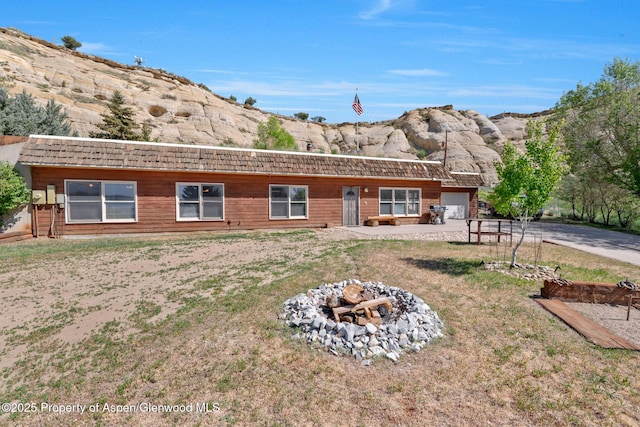 565 Sandrock Dr, Craig, CO 81625 - back of house with a fire pit, an attached garage, a yard, and driveway