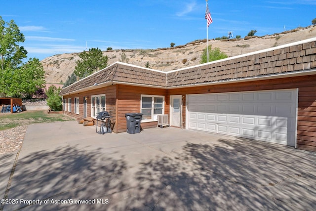 565 Sandrock Dr, Craig, CO 81625 - view of side of property with a mountain view, concrete driveway, mansard roof, central AC unit, and a garage