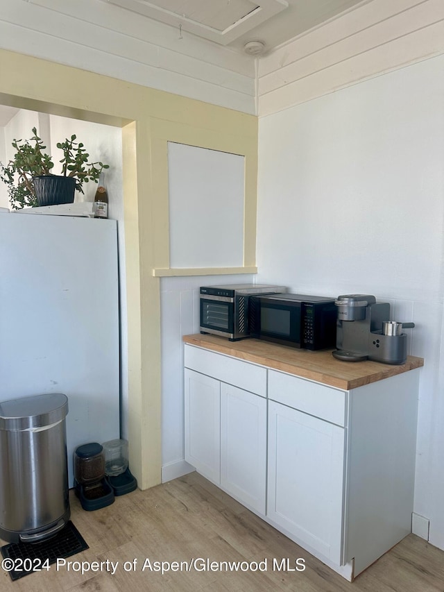 kitchen with white cabinets and light hardwood / wood-style flooring