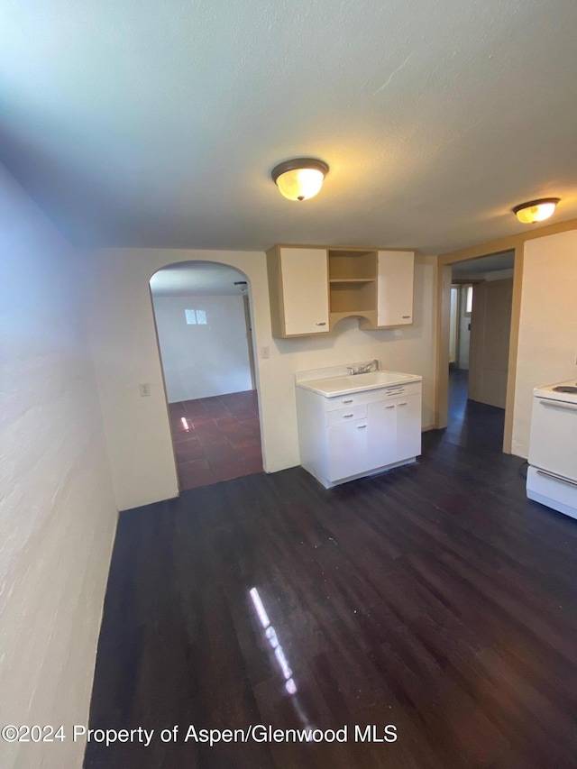 kitchen featuring electric stove, white cabinetry, and dark hardwood / wood-style floors