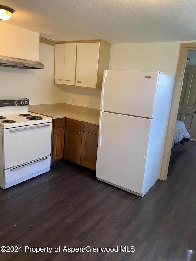 kitchen featuring dark hardwood / wood-style flooring, white appliances, and extractor fan