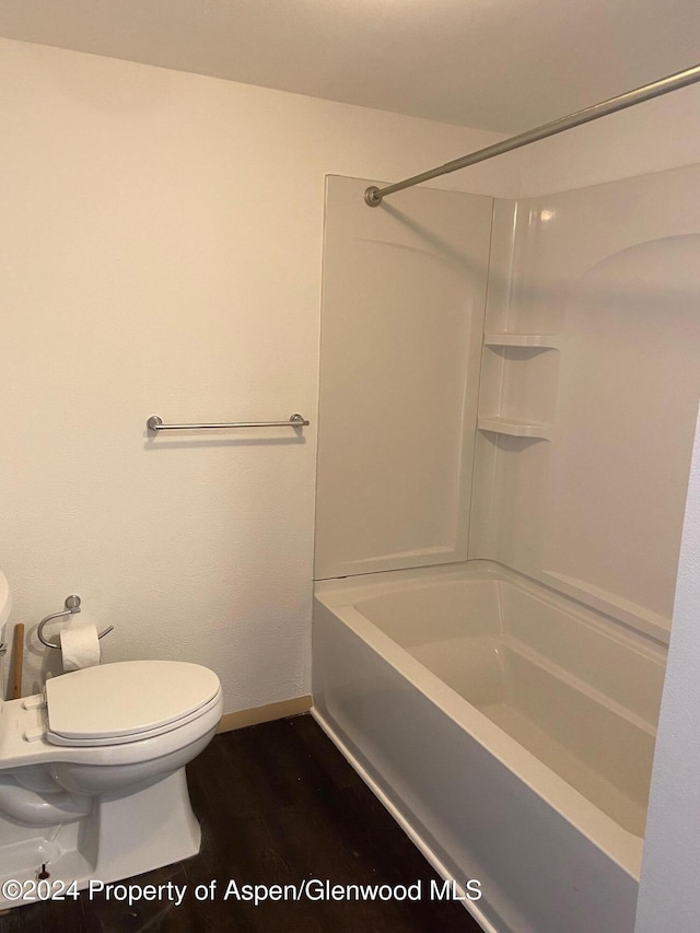 bathroom featuring hardwood / wood-style floors, shower / bath combination, and toilet