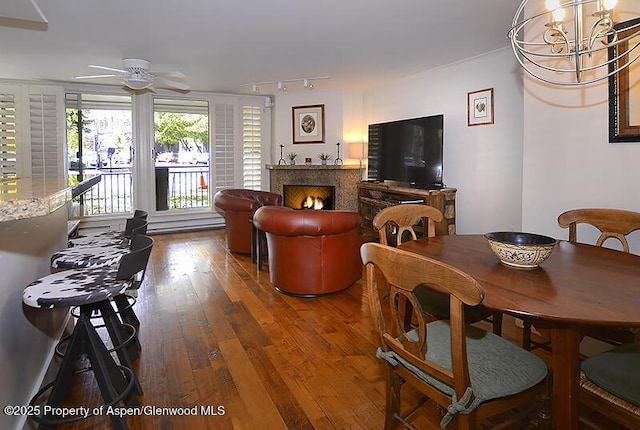 800 E Hopkins Ave Unit A-1, Aspen, CO 81611 - dining room with hardwood / wood-style floors, a lit fireplace, a ceiling fan, and rail lighting