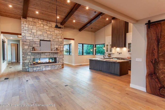 115 Sundance Trl, Carbondale, CO 81623 - kitchen with a kitchen island with sink, high vaulted ceiling, open floor plan, a barn door, and a wood ceiling with exposed beams