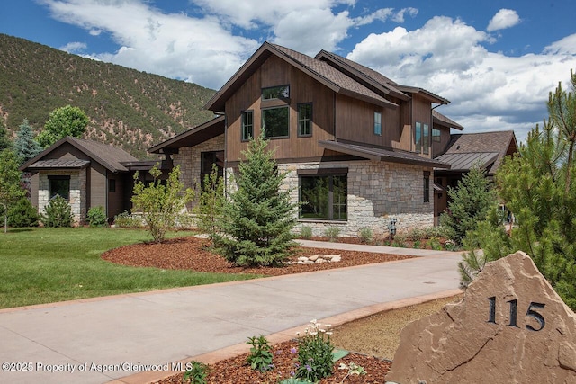 115 Sundance Trl, Carbondale, CO 81623 - view of front of home with stone siding, a standing seam roof, a front yard, a metal roof, and a mountain view
