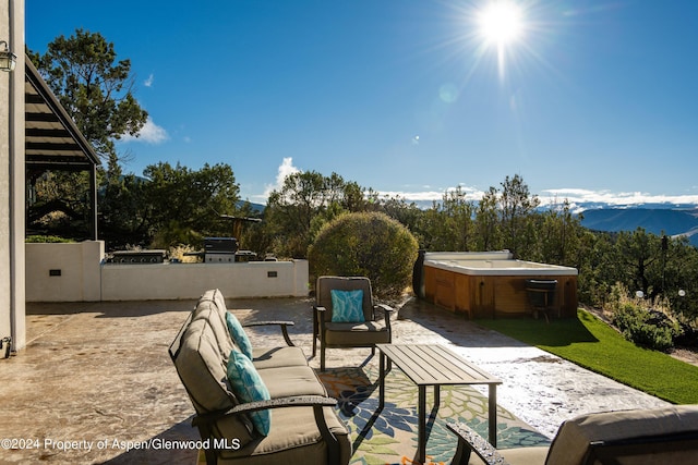 view of patio / terrace with a mountain view, grilling area, and a hot tub