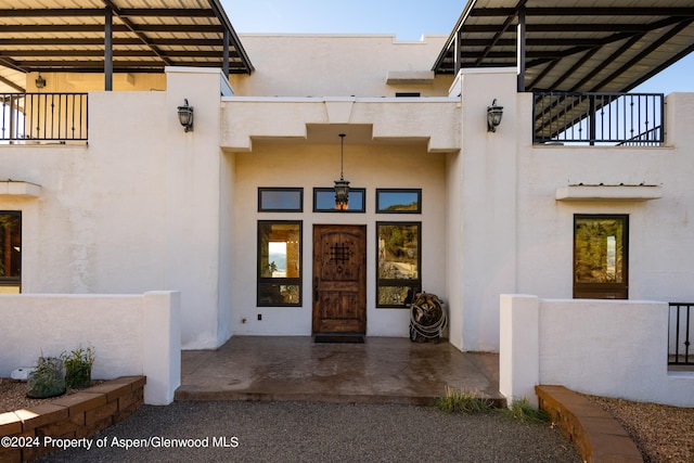 view of exterior entry featuring a balcony