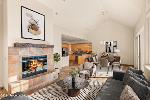 living room with high vaulted ceiling and a tiled fireplace