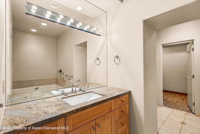 bathroom featuring a bathtub, tile patterned flooring, and vanity