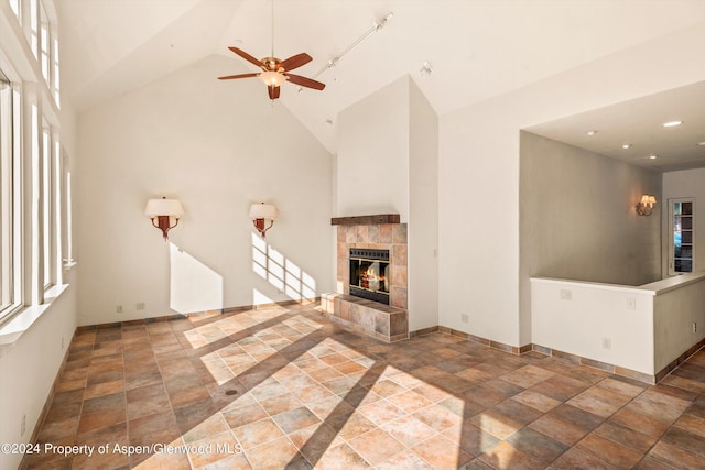 unfurnished living room with a fireplace, high vaulted ceiling, and a healthy amount of sunlight