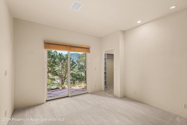 unfurnished room featuring light colored carpet