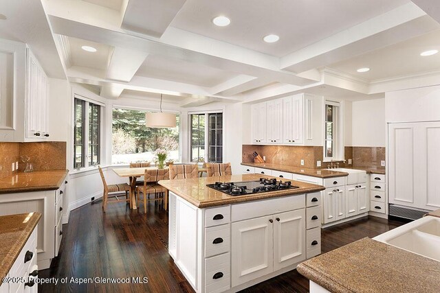74 Pfister Dr Unit 101, Aspen, CO 81611 - kitchen with coffered ceiling, dark wood-style floors, black cooktop, white cabinets, and beamed ceiling