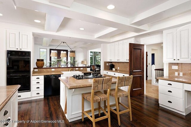 74 Pfister Dr Unit 101, Aspen, CO 81611 - kitchen with black appliances, tasteful backsplash, a breakfast bar, recessed lighting, and dark wood finished floors