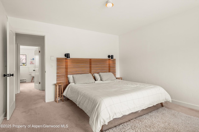 bedroom featuring baseboards, baseboard heating, and light carpet