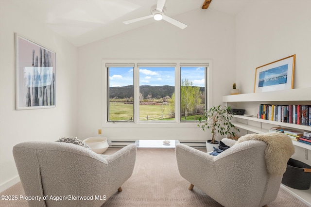 living area featuring a baseboard heating unit, carpet, a mountain view, a ceiling fan, and lofted ceiling
