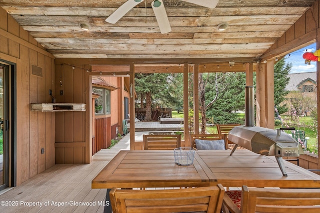 sunroom featuring outdoor dining space and ceiling fan