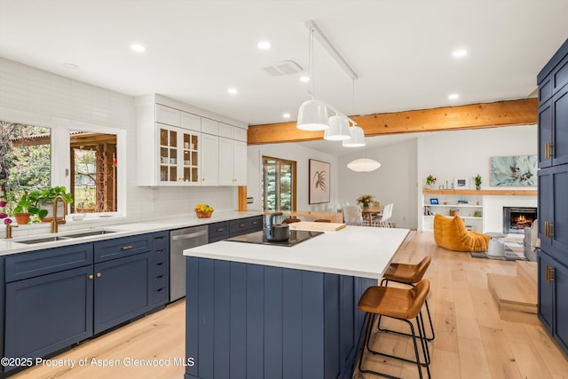 kitchen featuring a sink, light wood-style floors, black electric stovetop, a breakfast bar area, and stainless steel dishwasher