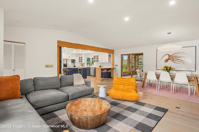 living area with recessed lighting, light wood finished floors, and vaulted ceiling
