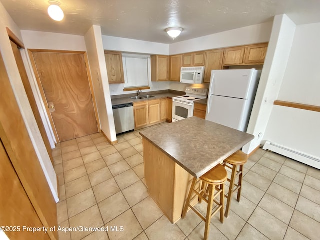 kitchen featuring white appliances, a baseboard heating unit, light brown cabinets, a center island, and a breakfast bar area