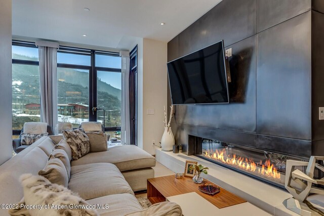 living room with a large fireplace and a healthy amount of sunlight