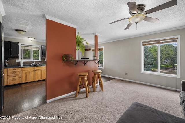 1617 W 7th St, Rifle, CO 81650 - kitchen featuring plenty of natural light, a breakfast bar, a ceiling fan, dark carpet, and a textured ceiling