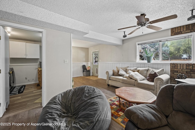 1617 W 7th St, Rifle, CO 81650 - living room featuring ceiling fan, a wainscoted wall, wood finished floors, and a textured ceiling