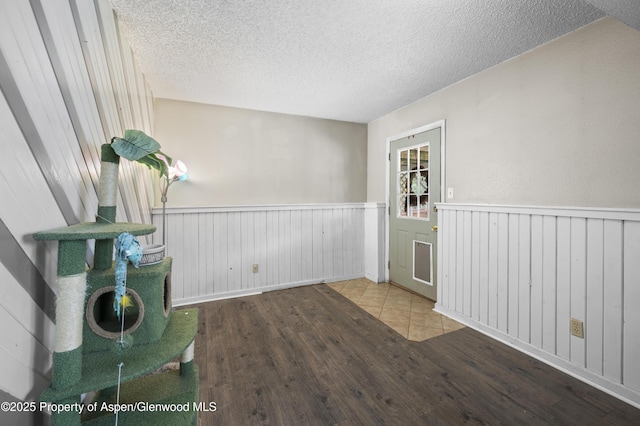 1617 W 7th St, Rifle, CO 81650 - empty room with wood finished floors, a wainscoted wall, and a textured ceiling