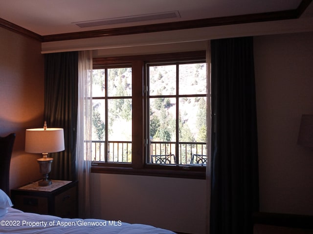 bedroom featuring crown molding and multiple windows