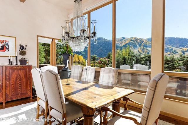 dining room with hardwood / wood-style flooring, a mountain view, and a chandelier