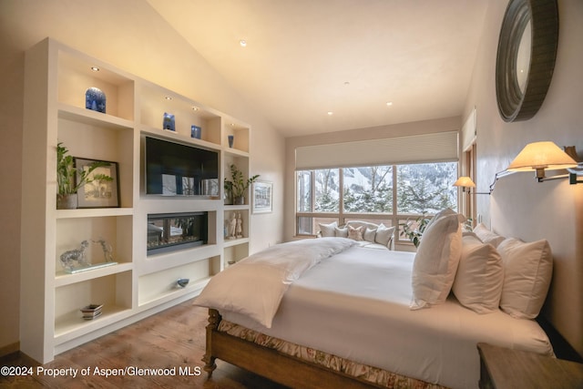 bedroom with vaulted ceiling and hardwood / wood-style floors