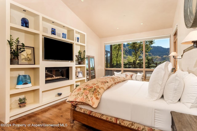 bedroom with vaulted ceiling and hardwood / wood-style floors