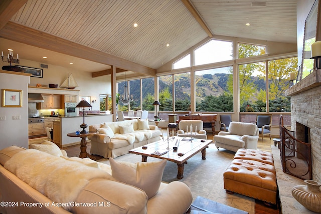 living room with beam ceiling, a mountain view, wood ceiling, and a fireplace