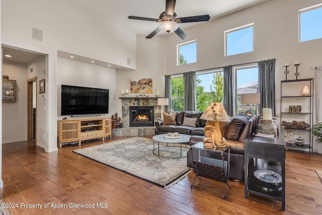 64 White Peaks Ln, Glenwood Springs, CO 81601 - living room with a towering ceiling, a glass covered fireplace, wood-type flooring, a ceiling fan, and baseboards