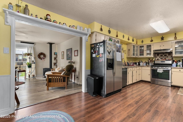kitchen featuring appliances with stainless steel finishes, under cabinet range hood, a textured ceiling, dark wood-style floors, and light countertops
