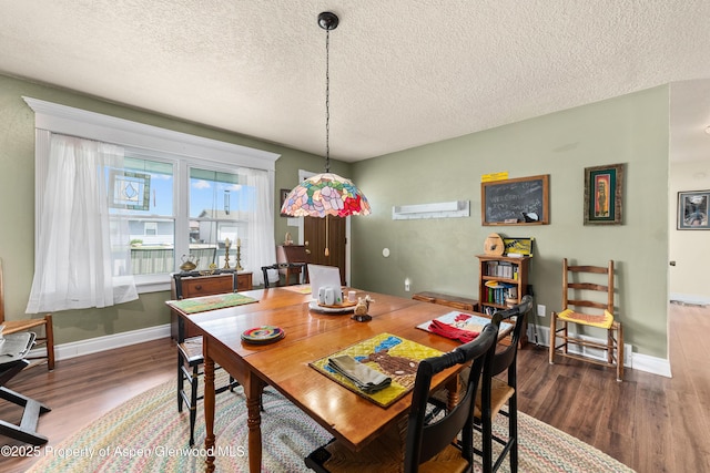 dining area with a textured ceiling, wood finished floors, and baseboards
