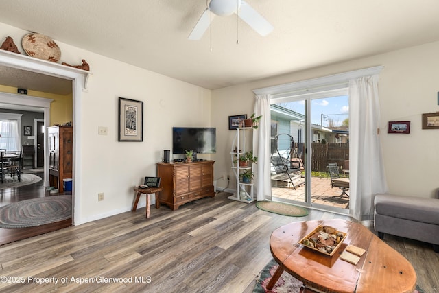 living room with wood finished floors, ceiling fan, and baseboards