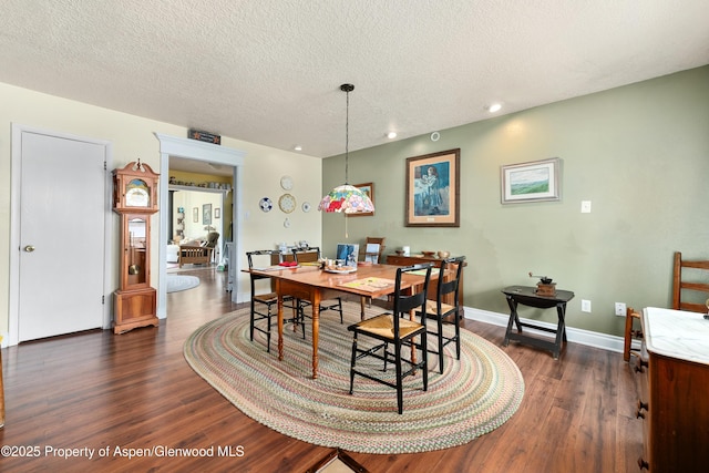 dining space featuring dark wood-style floors, recessed lighting, baseboards, and a textured ceiling