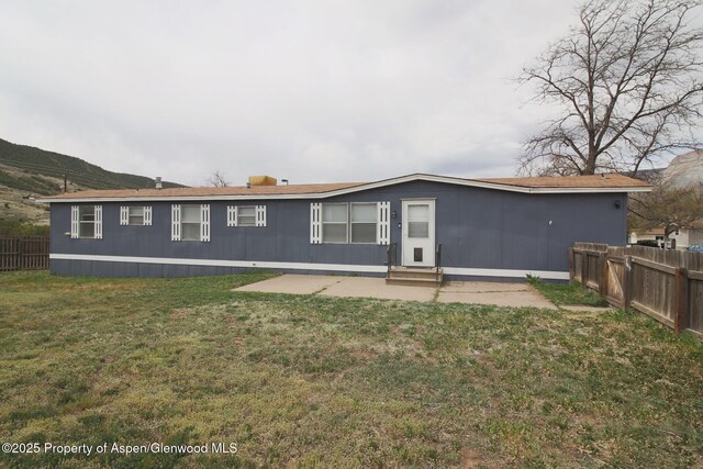 22 W Silver Bell Pl, Parachute, CO 81635 - rear view of property with a lawn, a fenced backyard, a patio, and entry steps