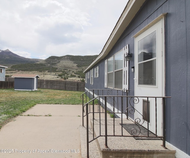 22 W Silver Bell Pl, Parachute, CO 81635 - view of patio featuring a fenced backyard, a mountain view, an outbuilding, and a storage shed