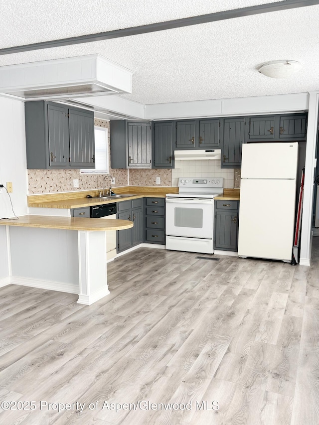 22 W Silver Bell Pl, Parachute, CO 81635 - kitchen featuring a peninsula, white appliances, light countertops, under cabinet range hood, and a sink