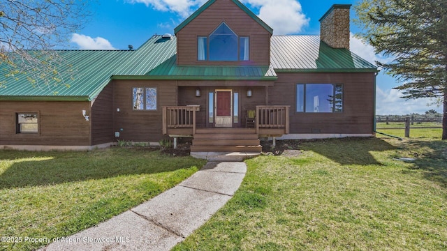 3 Red Wing Ln, Carbondale, CO 81623 - view of front of house featuring a chimney, metal roof, a porch, and a front lawn