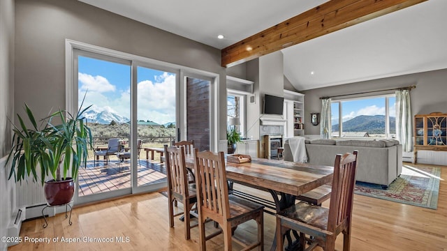 3 Red Wing Ln, Carbondale, CO 81623 - dining space with a fireplace, lofted ceiling with beams, baseboard heating, and light wood-style floors