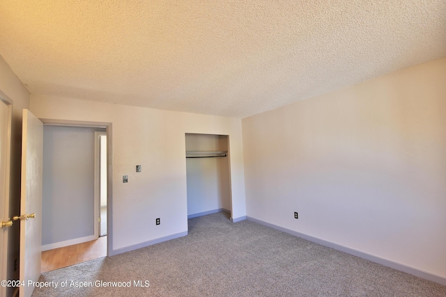 unfurnished bedroom featuring carpet floors and a textured ceiling