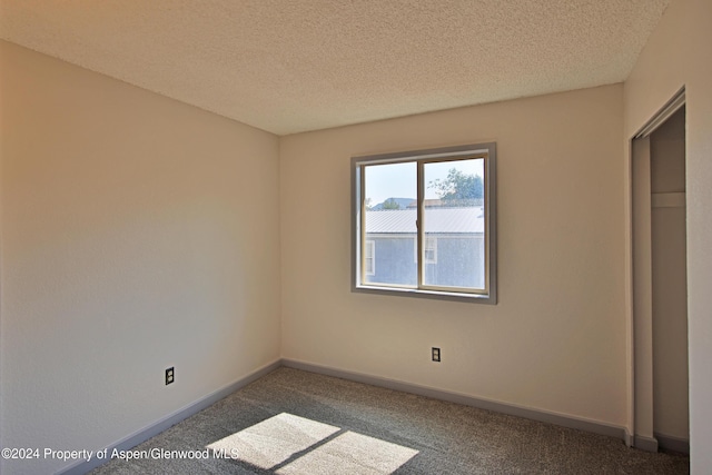 unfurnished bedroom with carpet floors and a textured ceiling