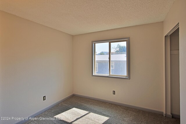 unfurnished bedroom with carpet floors and a textured ceiling