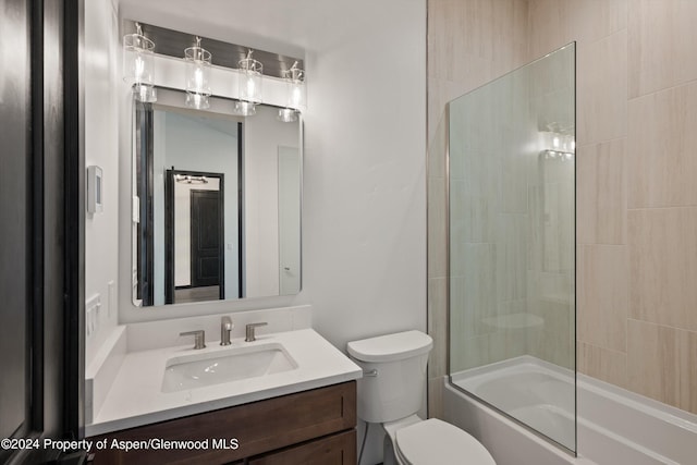 full bathroom featuring combined bath / shower with glass door, vanity, and toilet