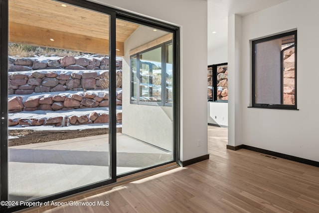 doorway to outside featuring hardwood / wood-style flooring and lofted ceiling