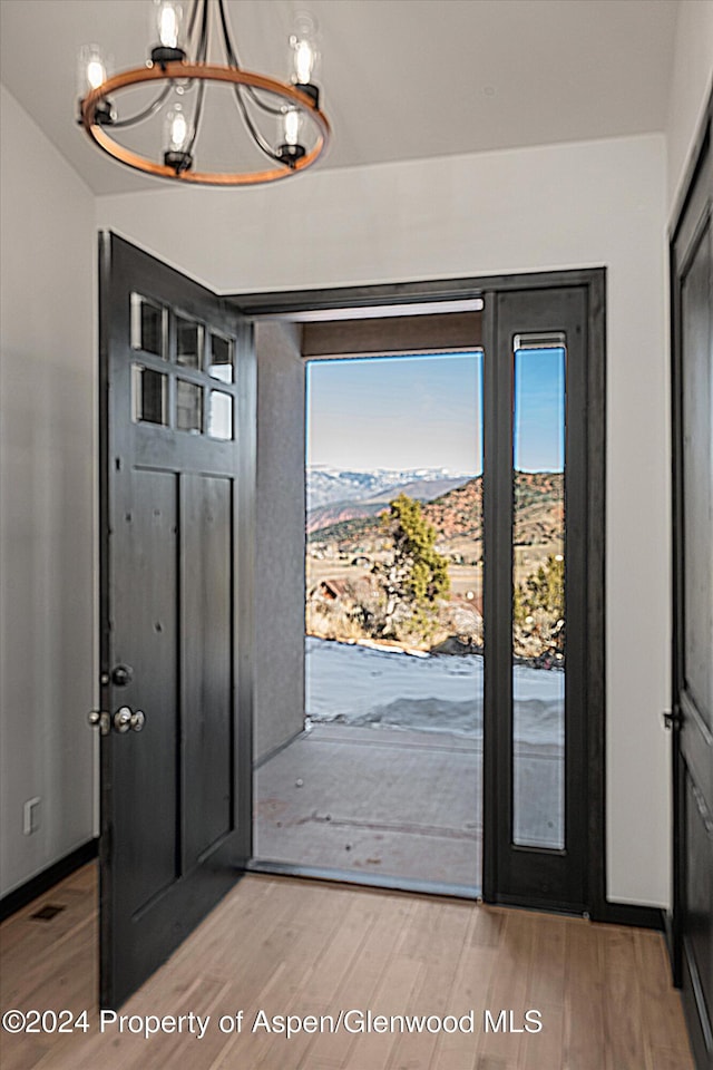 entrance foyer featuring hardwood / wood-style flooring, a wealth of natural light, and a chandelier